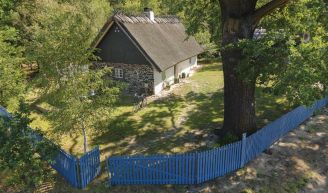 Dom Olędrów w Puszczy Pyzdrskiej urządzony w rustykalnym stylu i pokryty strzechą Dom Olędrów z zewnątrz