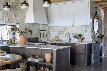 Jasny salon z narożną sofą, kamienną ścianą i drewnianym sufitem