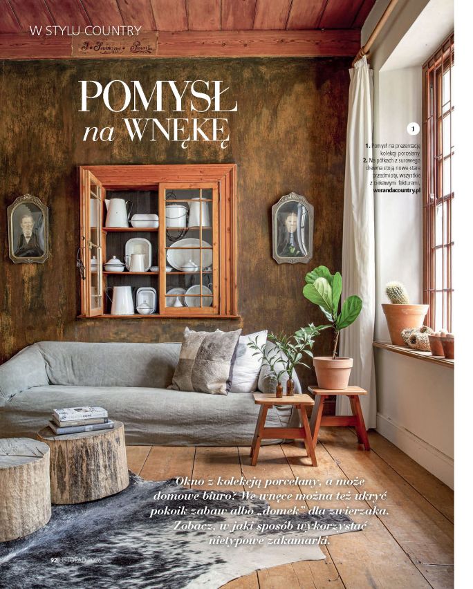 Rustykalne wnętrze w stylu country z drewnianą podłogą, lnianą sofą, stolikami z surowego drewna, roślinami i wnęką z kolekcją białej porcelany. Na stronie widnieje tytuł „Pomysł na wnękę”.