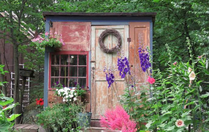 Stary domek ogrodowy można odmalować i ozdobić kwiatami.