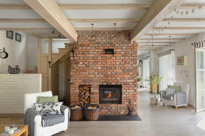 Stare cegły, drewno i biel - połączenie idealne do salonu w stylu rustykalnym