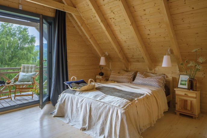 Przytulna sypialnia na poddaszu w jasnym drewnie