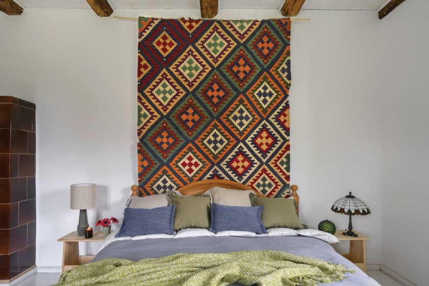 Mazurski dom z zielonym gankiem łóżko i kilim